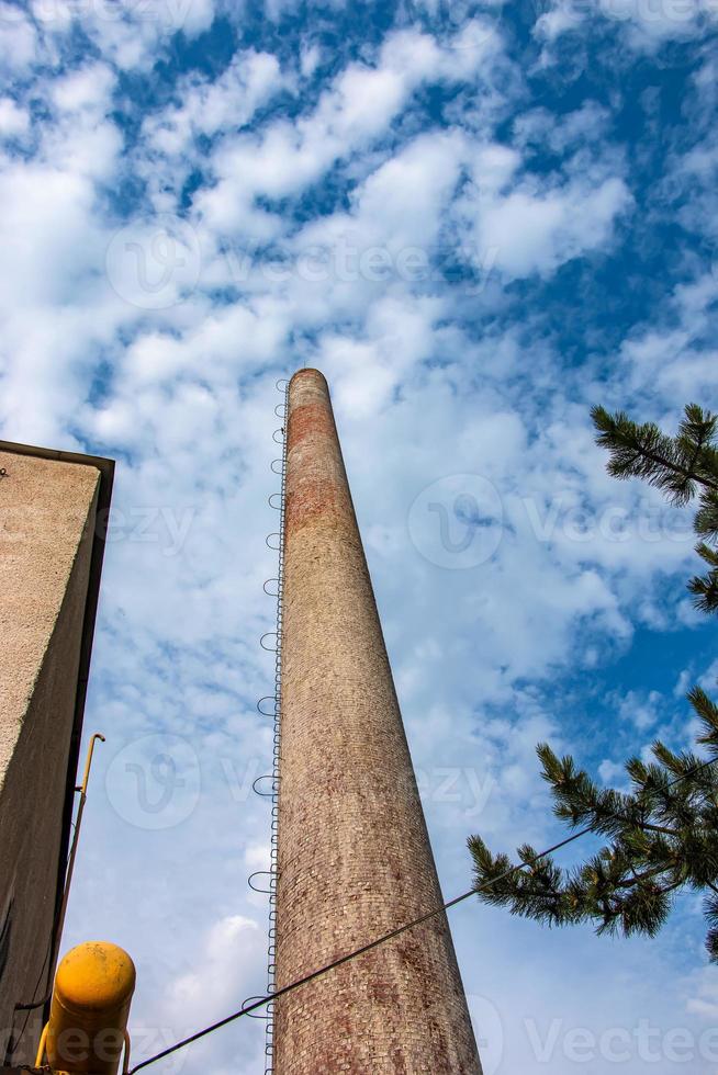 The pipe of a gas boiler house against the blue sky. No smoke comes out of the chimney. Energy crisis. photo