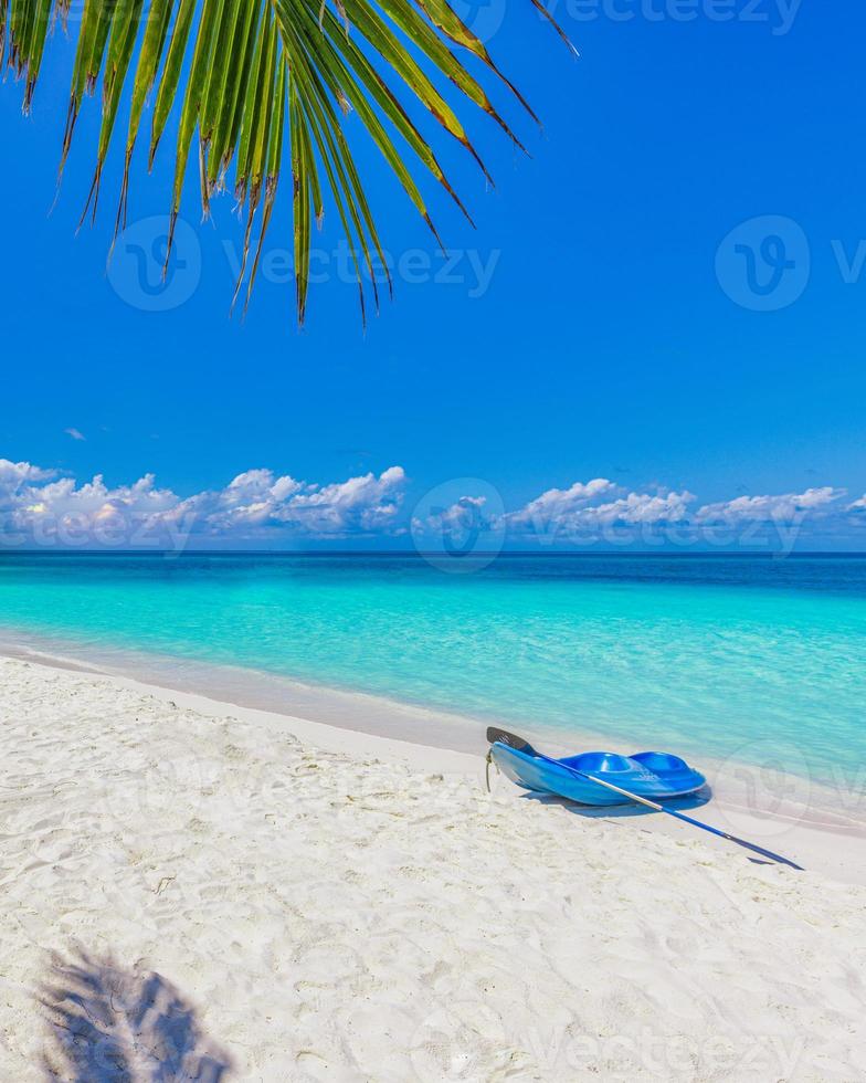 playa de la isla de maldivas con kayak azul en la orilla. paisaje tropical de verano, arena blanca con palmeras. destino de vacaciones de viaje de lujo. paisaje de playa exótico. naturaleza asombrosa, relax, libertad foto