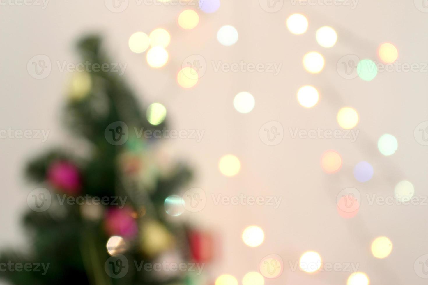 blurred christmas tree with decorations and light bokeh background photo