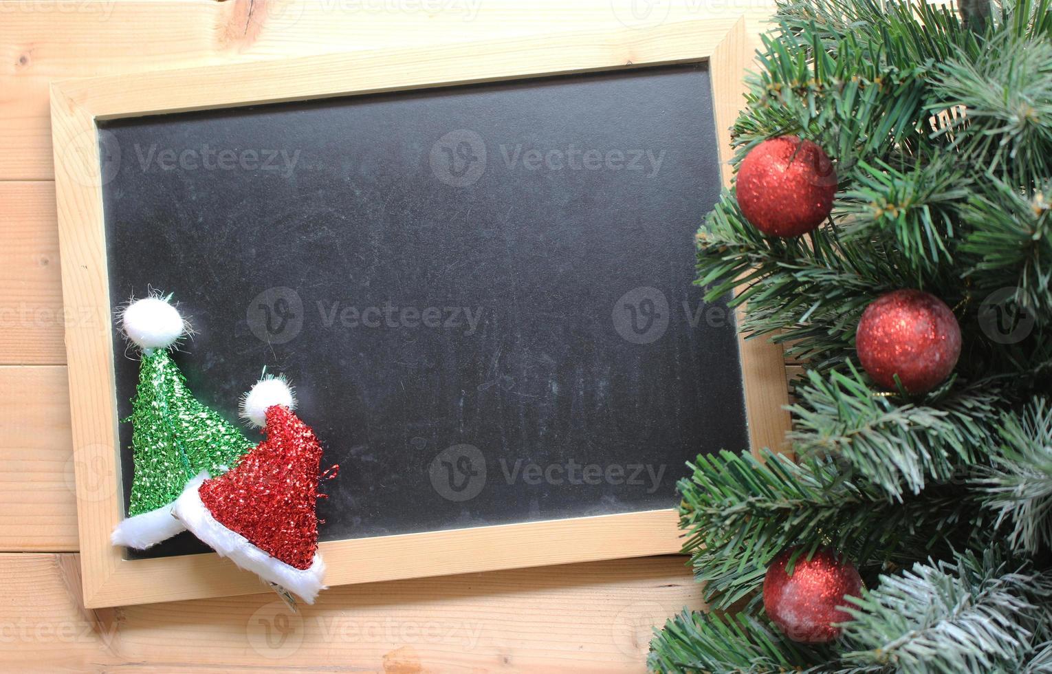 christmas tree with decorations ball on and blackboard on wooden background photo