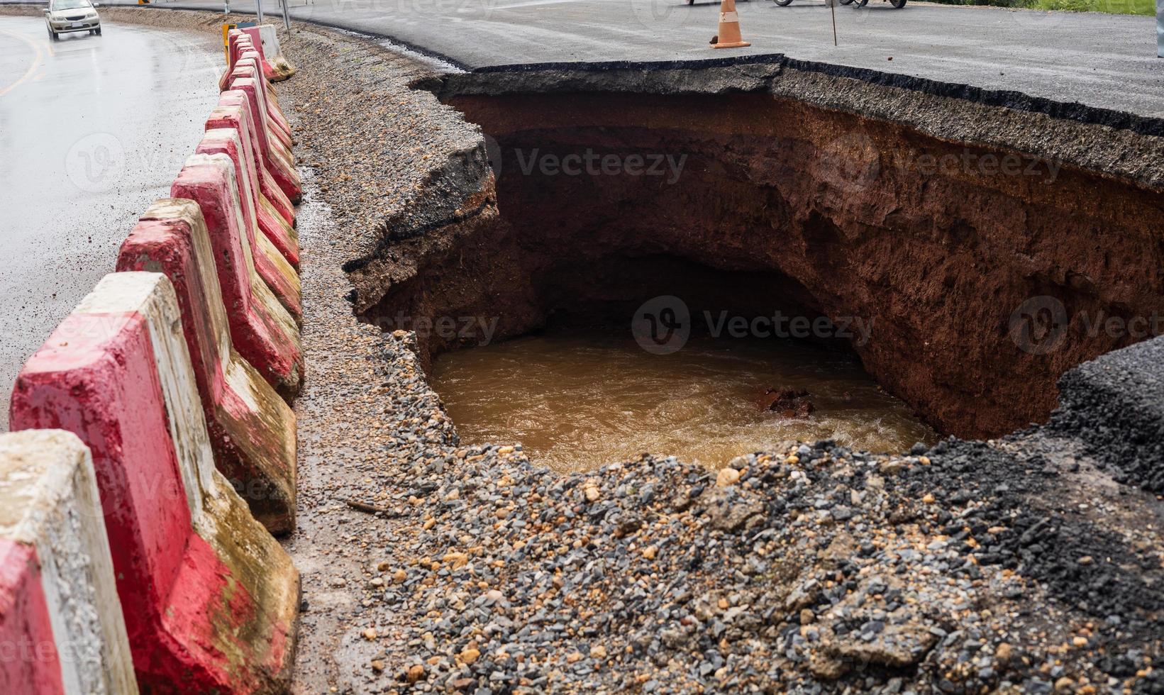 The road was destroyed by water erosion caused by heavy rain and flooding the road. photo