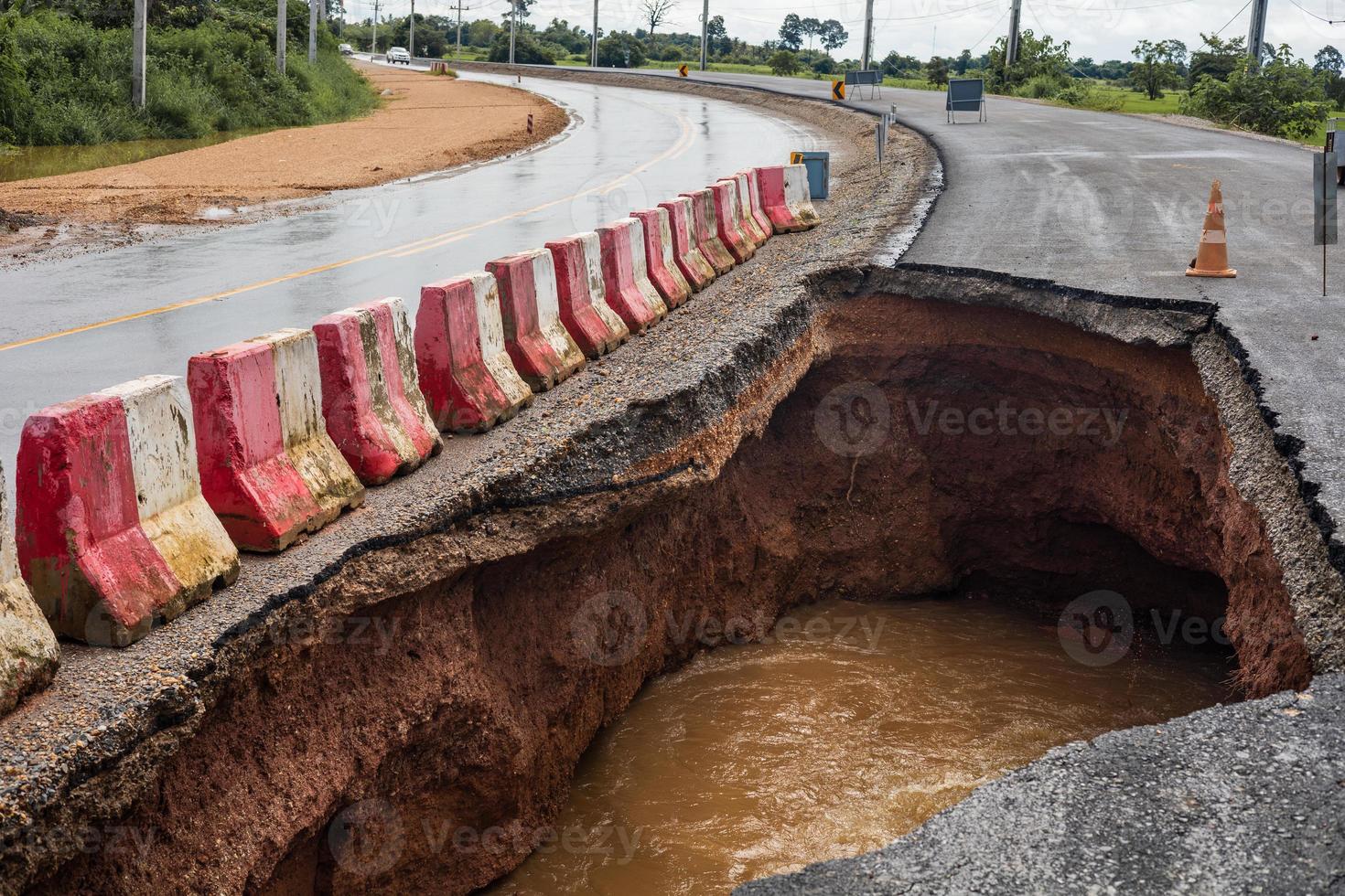 The road was destroyed by water erosion caused by heavy rain and flooding the road. photo
