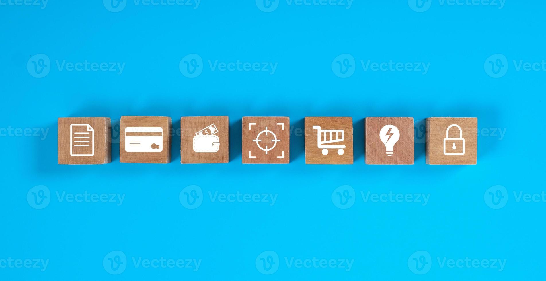 Square wooden blocks on blue background with concept of finance icon. photo