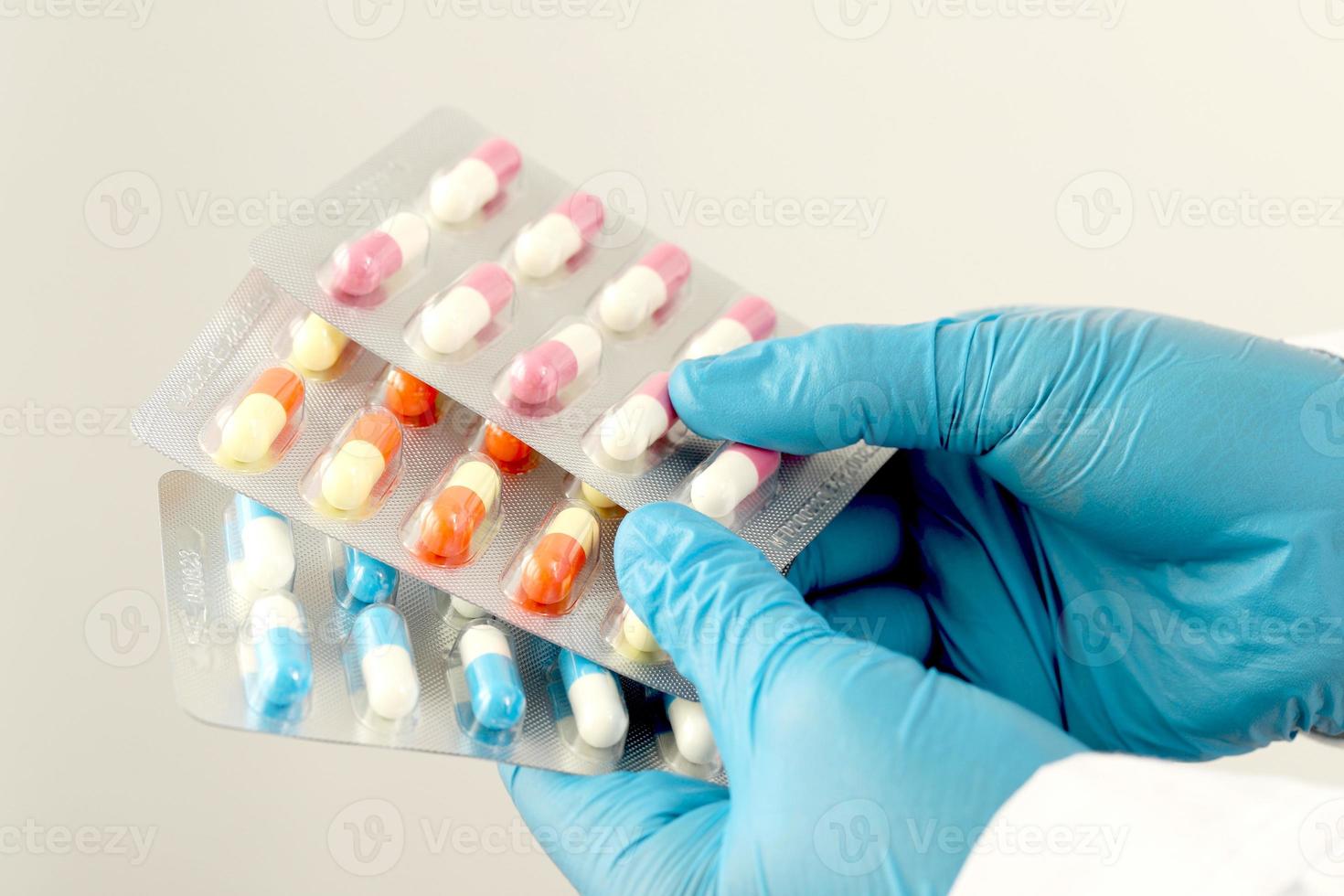 The pharmacist or doctor holds the antibiotic capsules and gives them to the patient or person. overuse of antibiotics antimicrobial resistance white background photo