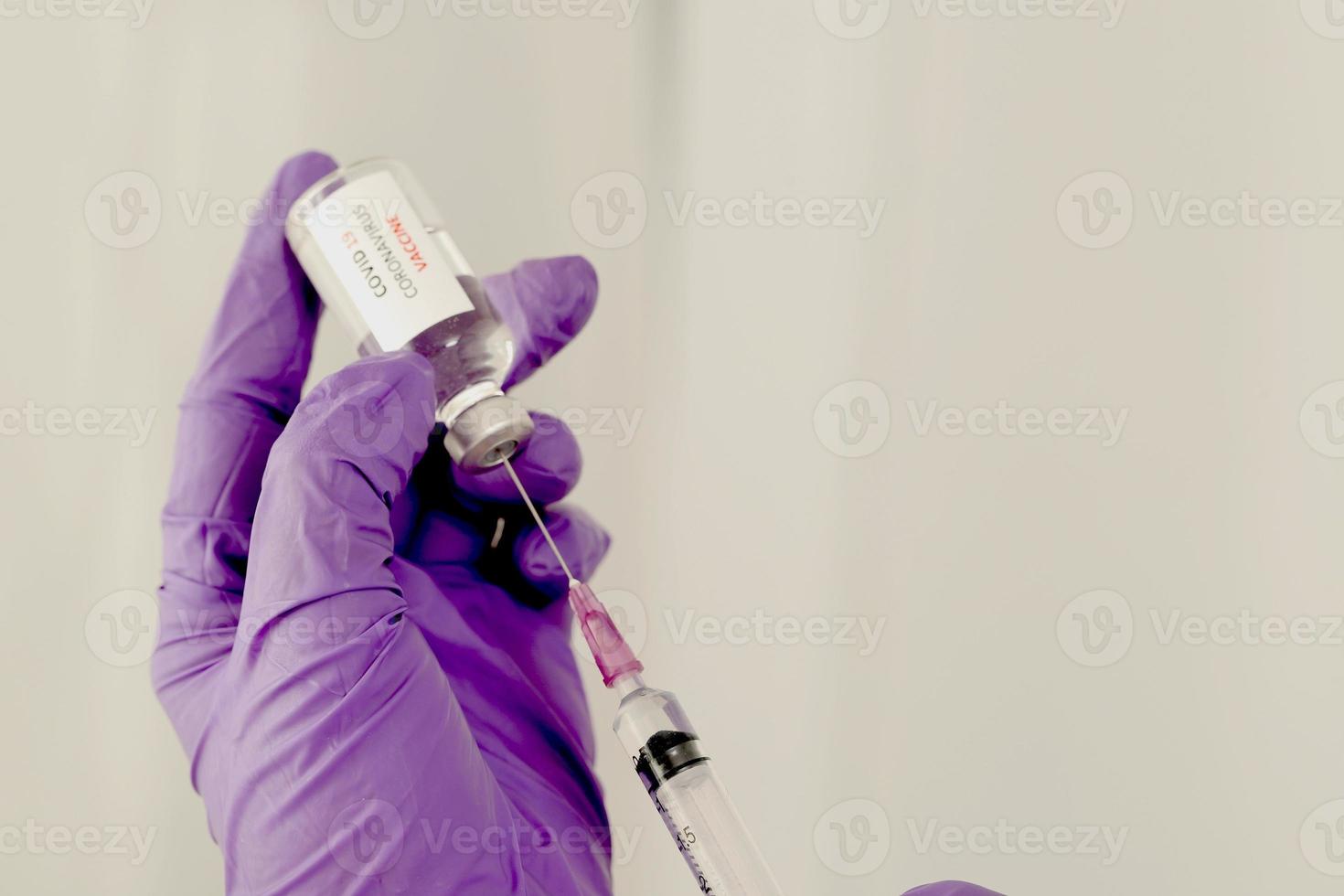 Covid-19 vaccine in the hands of researchers female doctor holding a syringe and a bottle of medicine with vaccine for injecting immunity from covid 19 photo