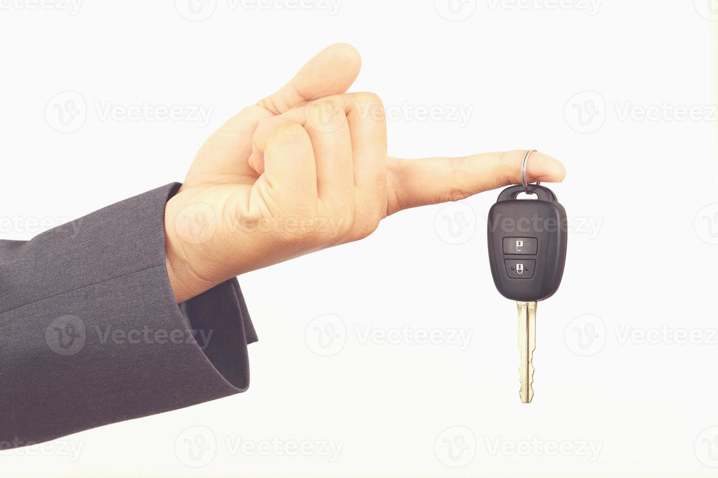 Salesman is carrying the car keys delivered to the customer at the showroom with a low interest offer. Special promotion photo