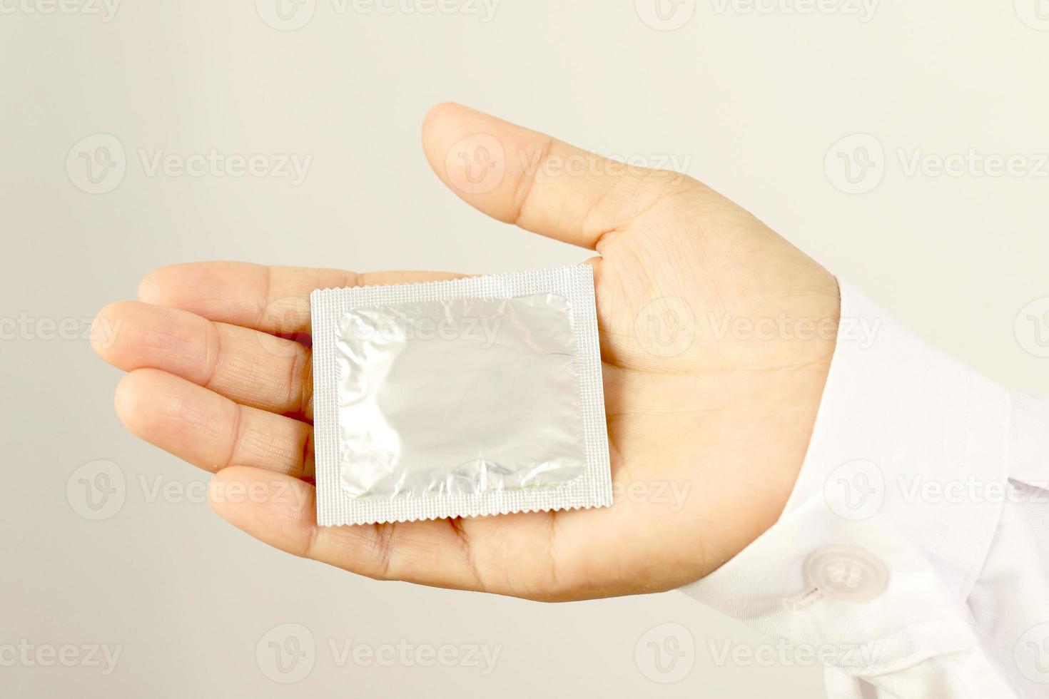 Focus hand,Yong woman use condoms before having sex every time to prevent AIDS. photo