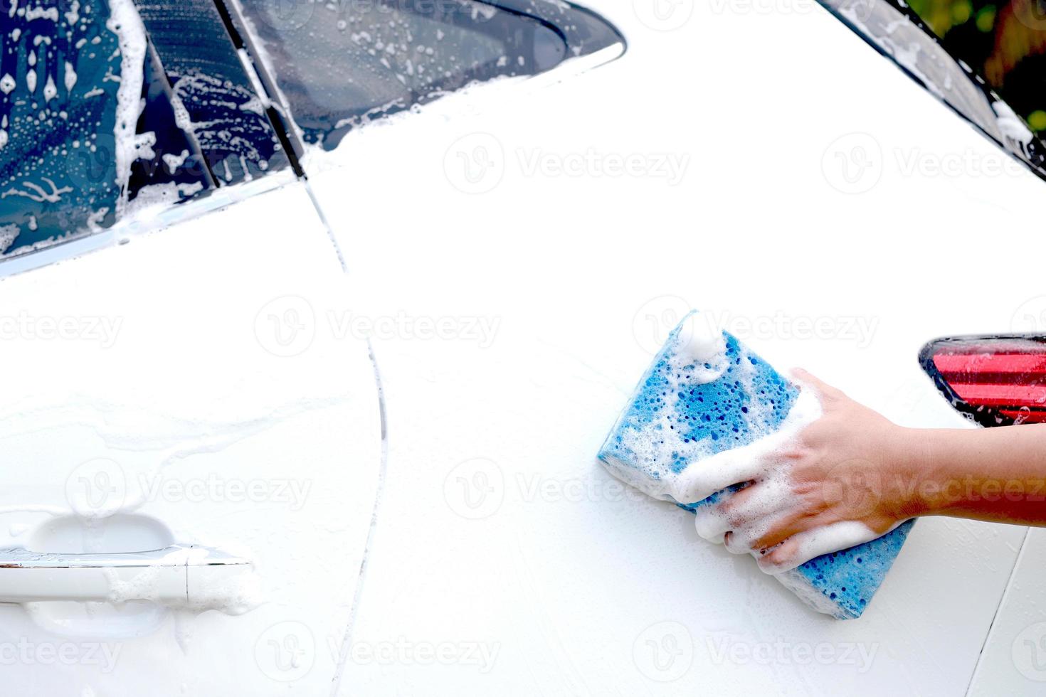 This man is washing the car and cleaning the car. photo