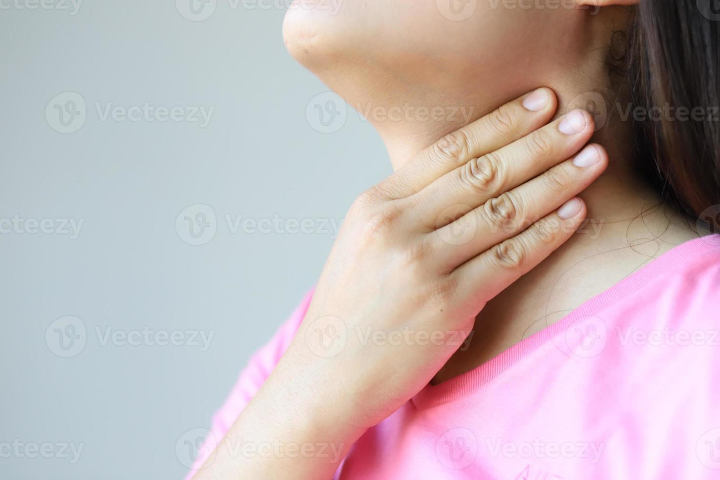 A pink shirt lady with a sore throat needs a doctor at the hospital. photo