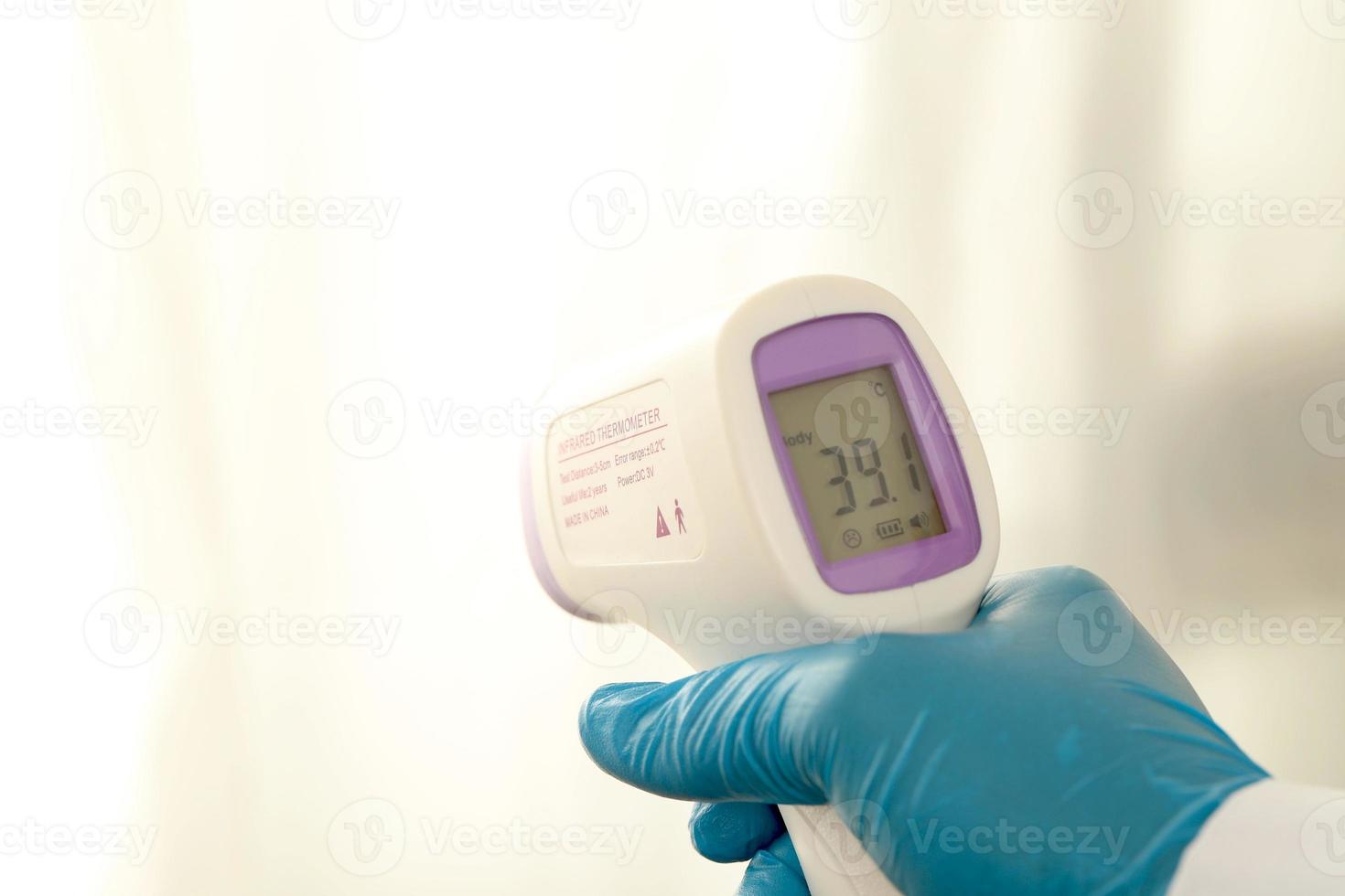 thermometer gun handheld forehead reading temperature measuring device isolated on white background photo