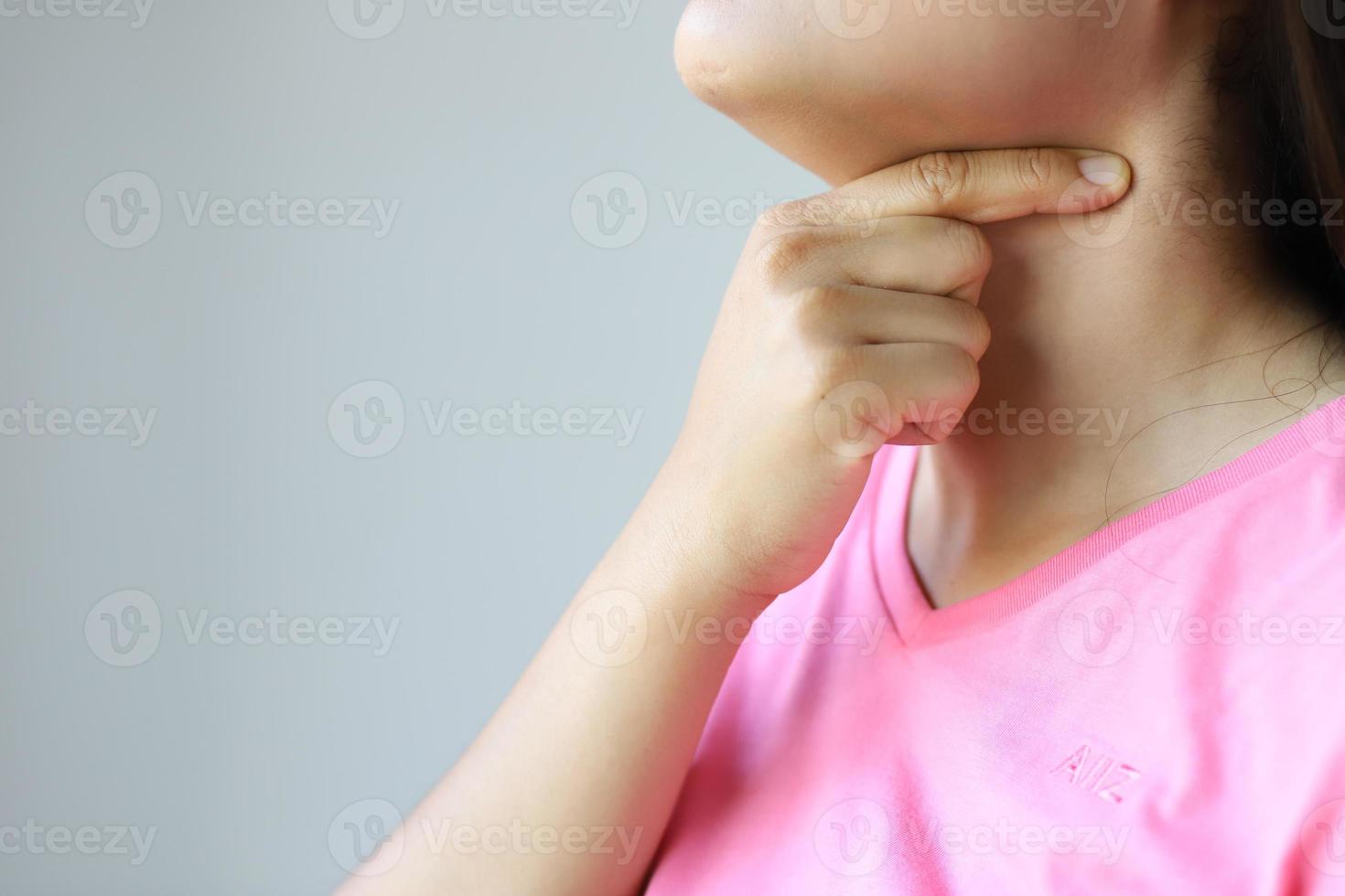 A pink shirt lady with a sore throat needs a doctor at the hospital. photo