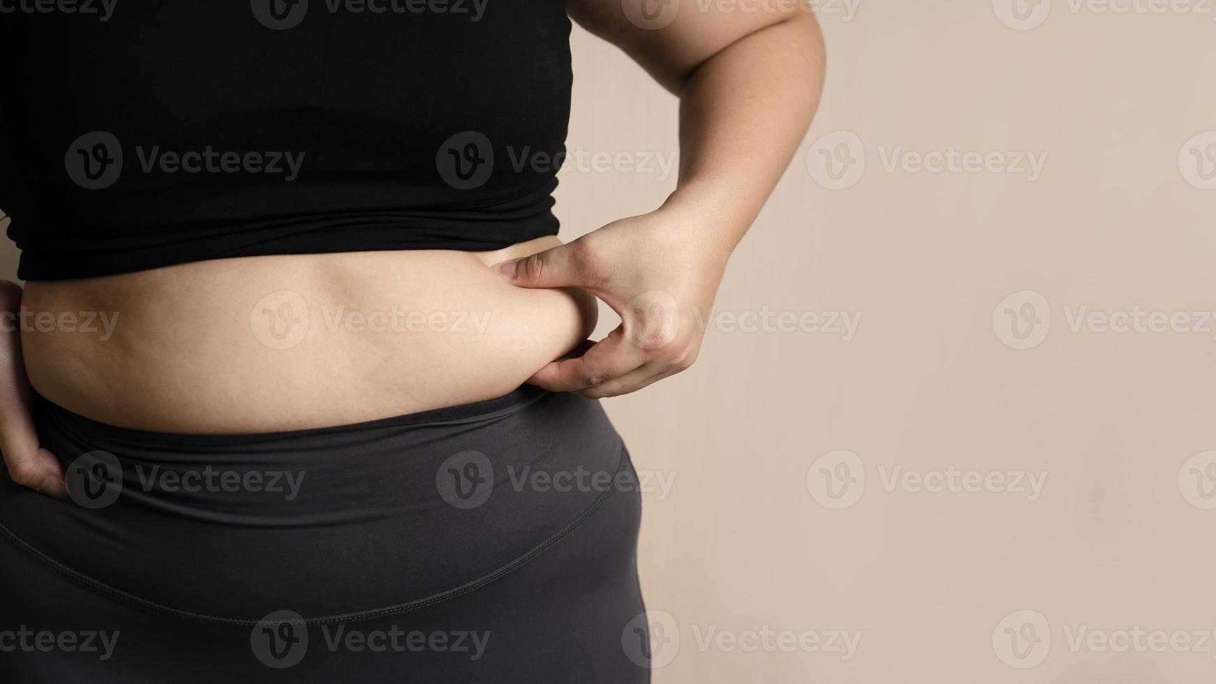 Fat woman's hand holding too much belly fat. fat belly chubby. diet lifestyle concept for women to lose weight photo