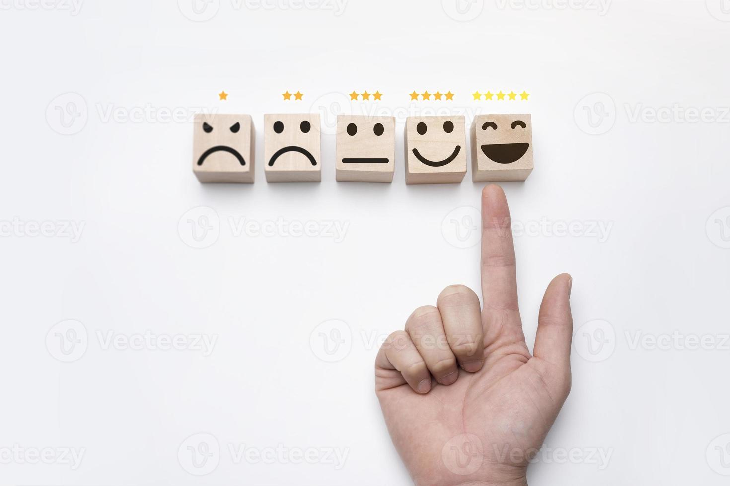 máxima calidad de servicio. la mano del cliente calificó la satisfacción más alta con calificación de 5 estrellas. mejor servicio, encuesta, el bloque de madera tiene un emoticón foto