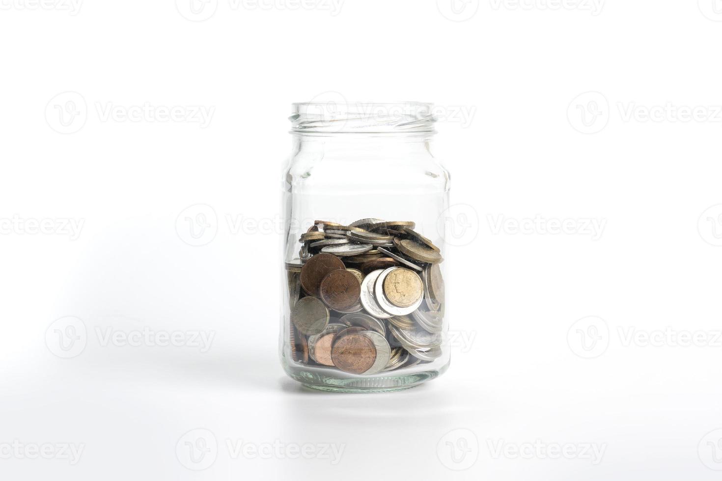 Coin into a glass jar isolated on white background. money saving concept, financial business investment, coin in glass bottle photo