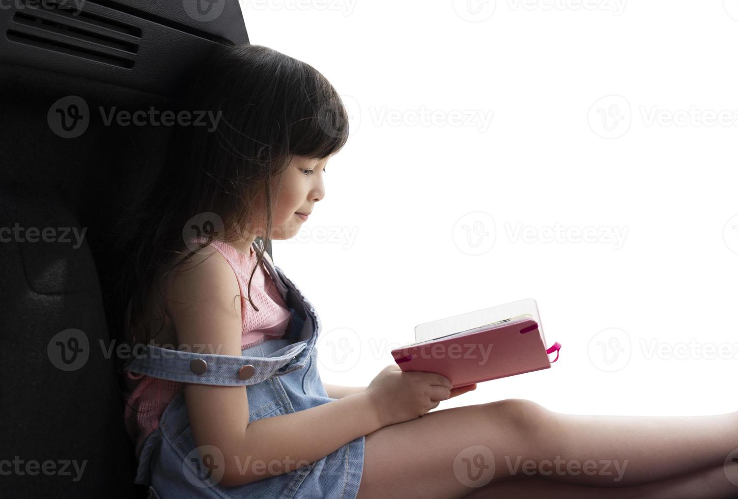 beautiful girl sitting and reading a pink book wanting to be happy, reading books for learning photo