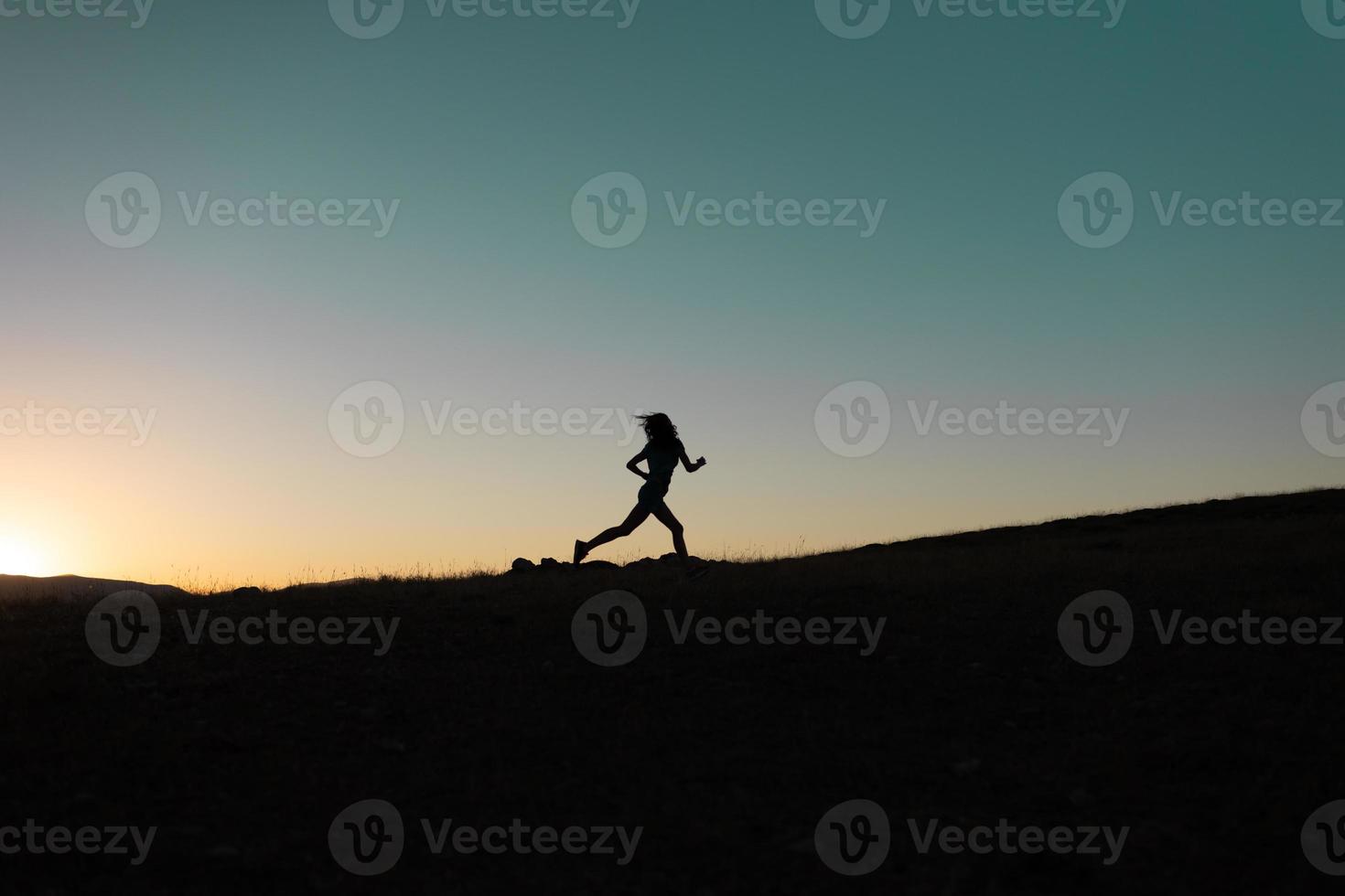 chica corre al atardecer en las montañas. foto