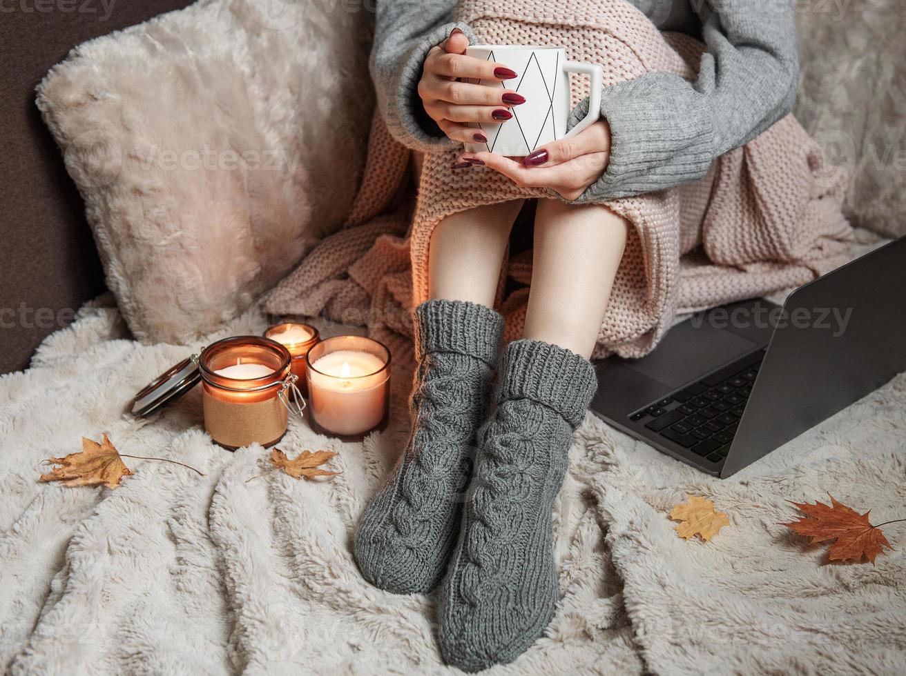 Cozy home, woman covered with warm blanket, drinks coffee. photo