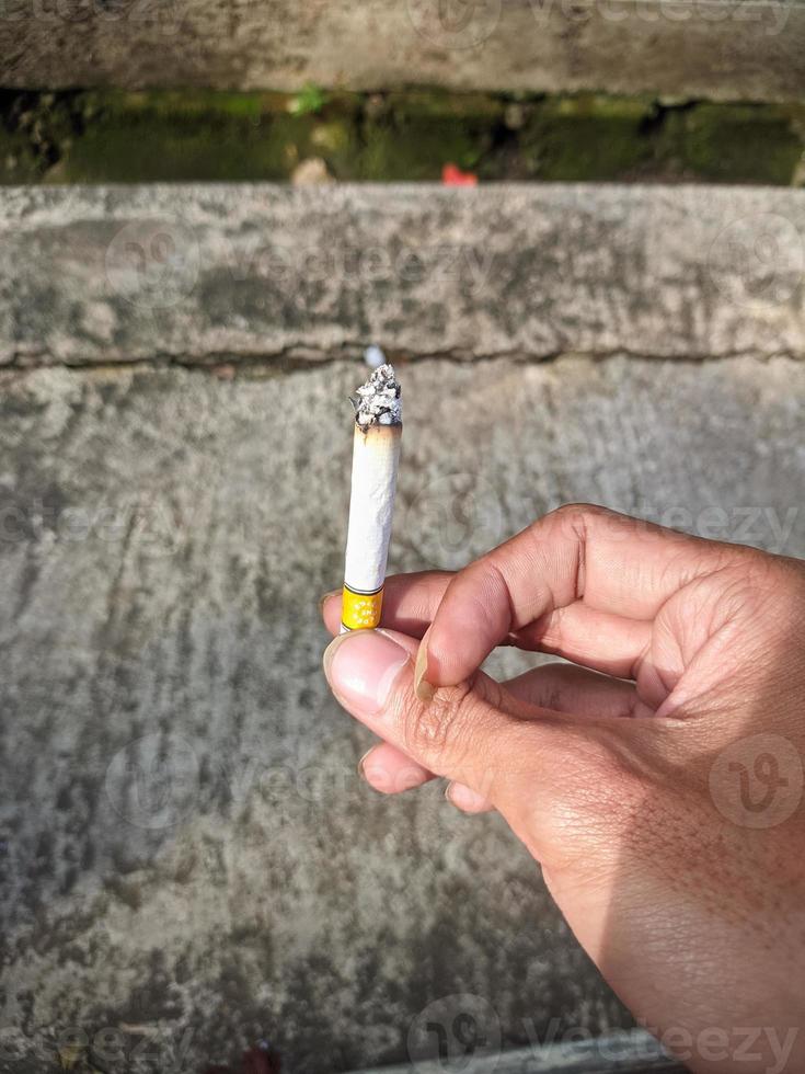 foto de primer plano de la mano derecha de un hombre fumando un cigarrillo