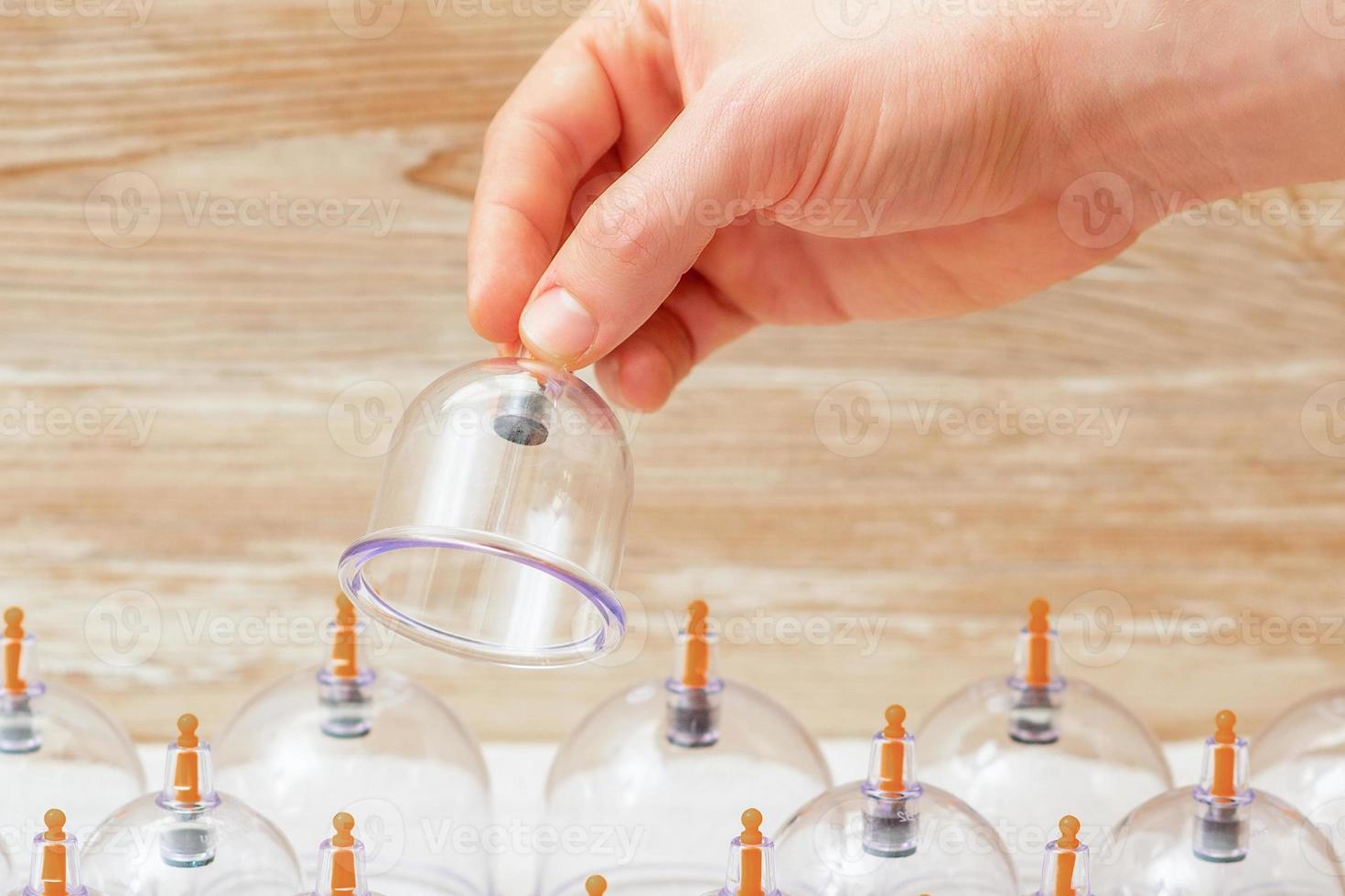 massager's hand holding vacuum glass jar photo