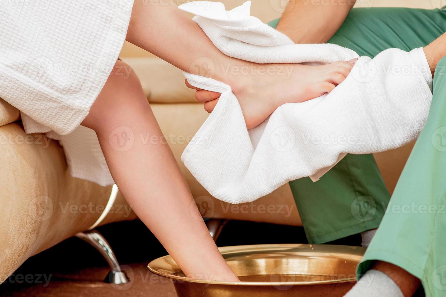 Male hands cleaning foot of woman. photo