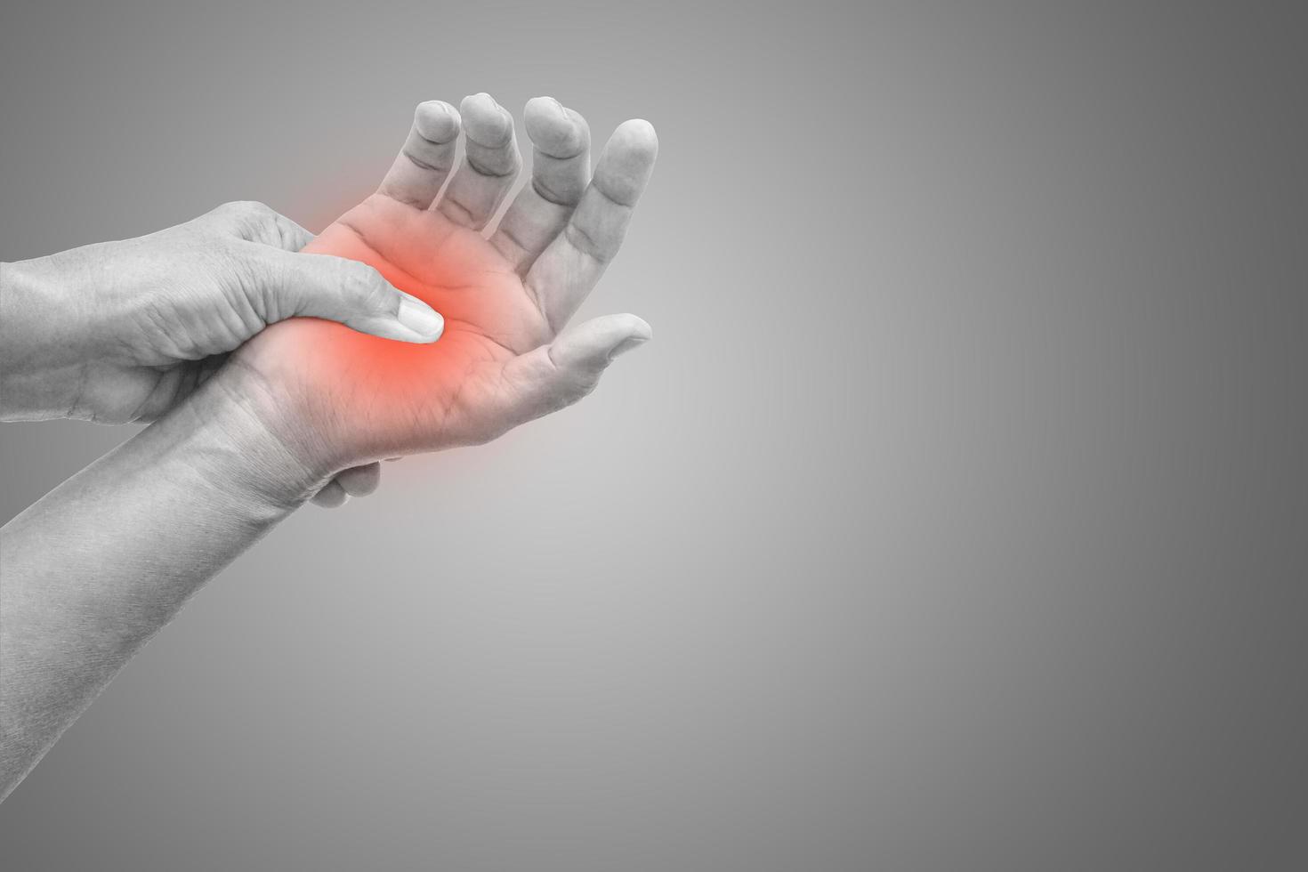 Woman with hand pain black and white photo with red dot on gradient background. Healthcare and office syndrome concept.