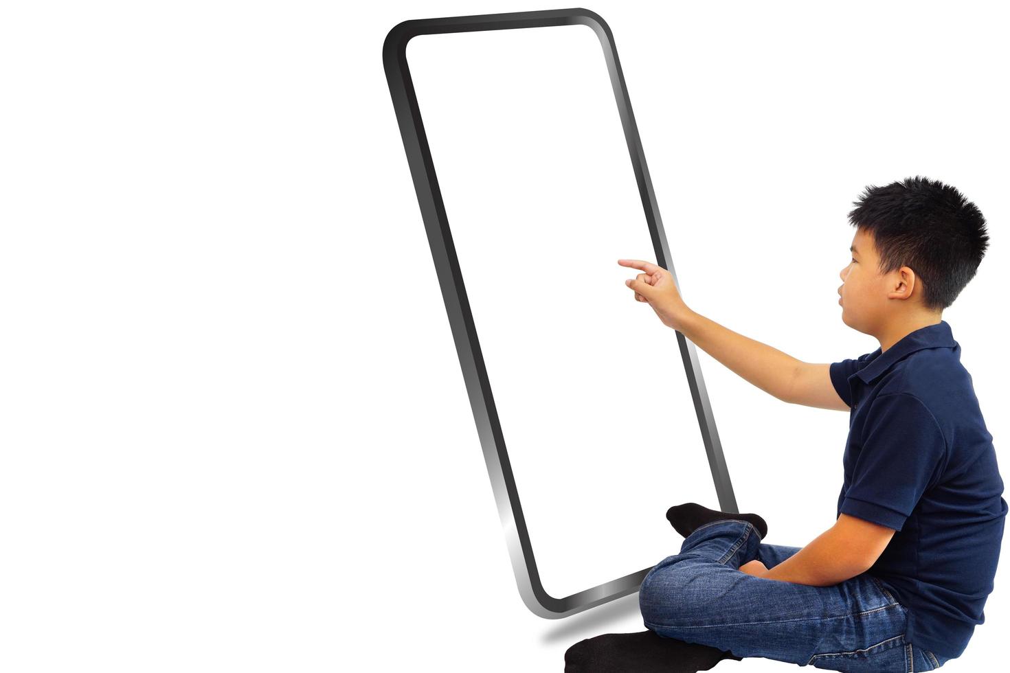 el niño sentado en un fondo blanco y toca una gran pantalla de teléfono móvil. concepto de educación y tecnología. foto