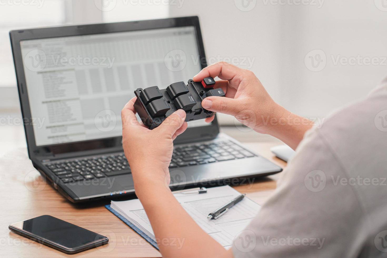 Close up hand a man hold Set of switches for adjusting electric car windows and check part detail number and order new part for service work in maintenance shop photo