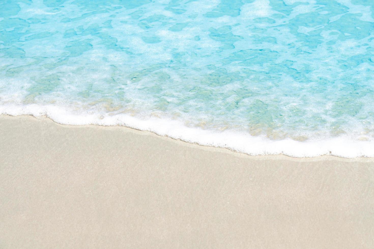 cerrar suave hermosa ola del océano en la playa de arena para el fondo foto