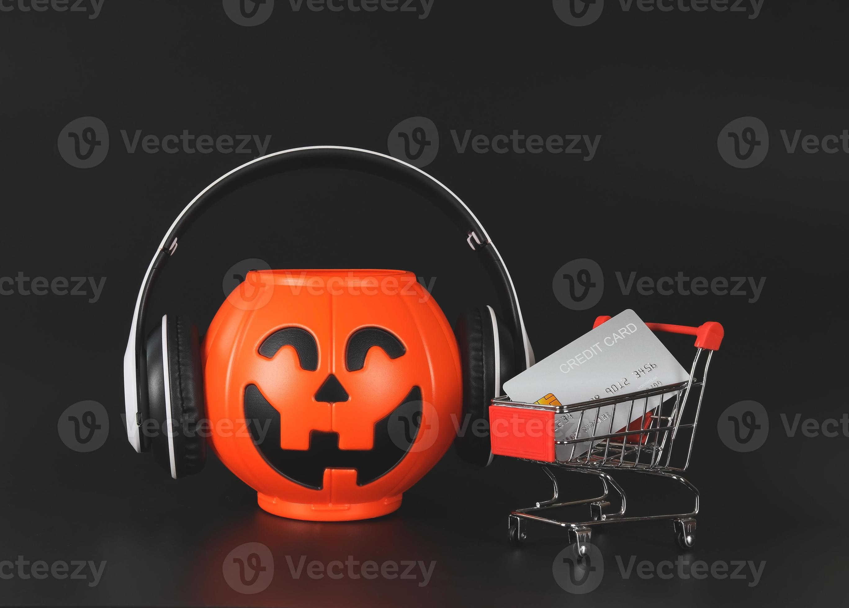 plastic Halloween pumpkin bucket covere with headphones isolated