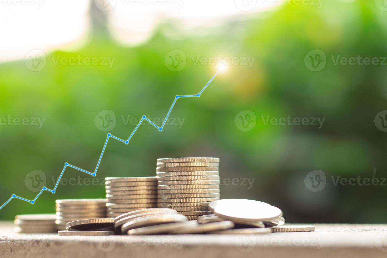 el gráfico superior encima de un montón de monedas con fondo de naturaleza verde borrosa, concepto de crecimiento de dinero e inversión sostenible, éxito empresarial y concepto financiero, idea bancaria y económica foto