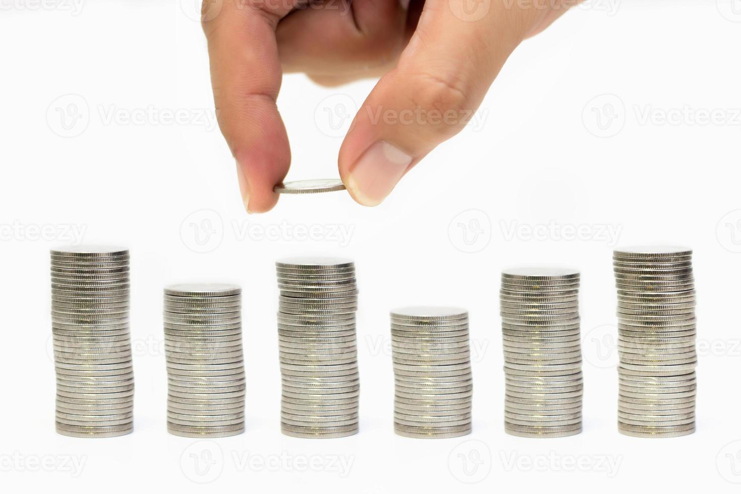 Man hand holding coin with coins stack arranged as graph on white background, Money growing concept and sustainable investment, Business success and financial concept, Banking and economy idea photo