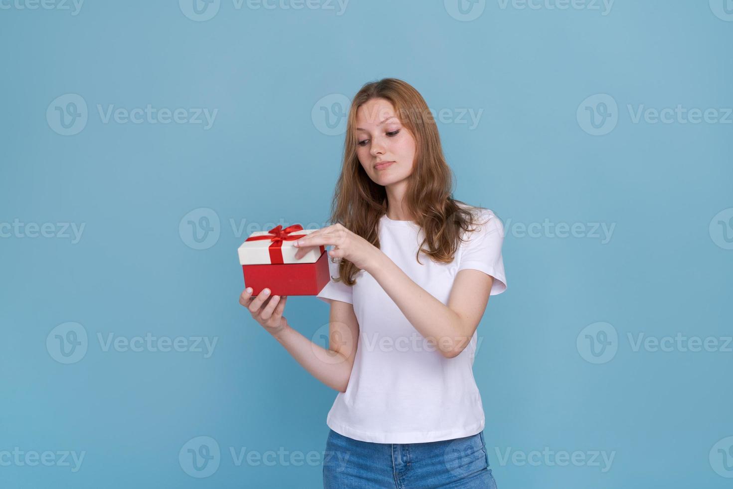 Excited young woman in white t-shirt isolated on blue background. photo