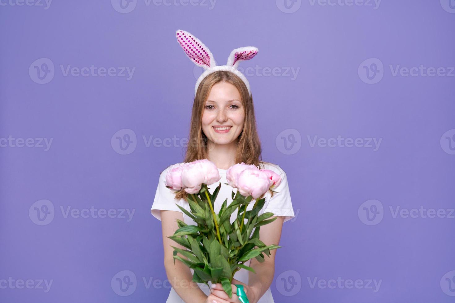 Charming happy cute girl with pink easter bunny ears and bouquet spring photo