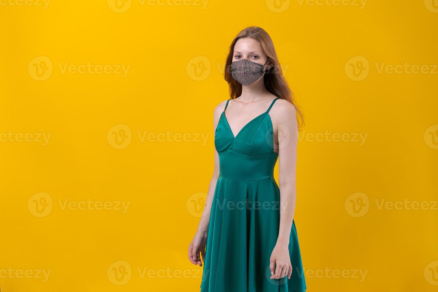 Beautiful young woman protection mask wearing for coronavirus disease on yellow photo