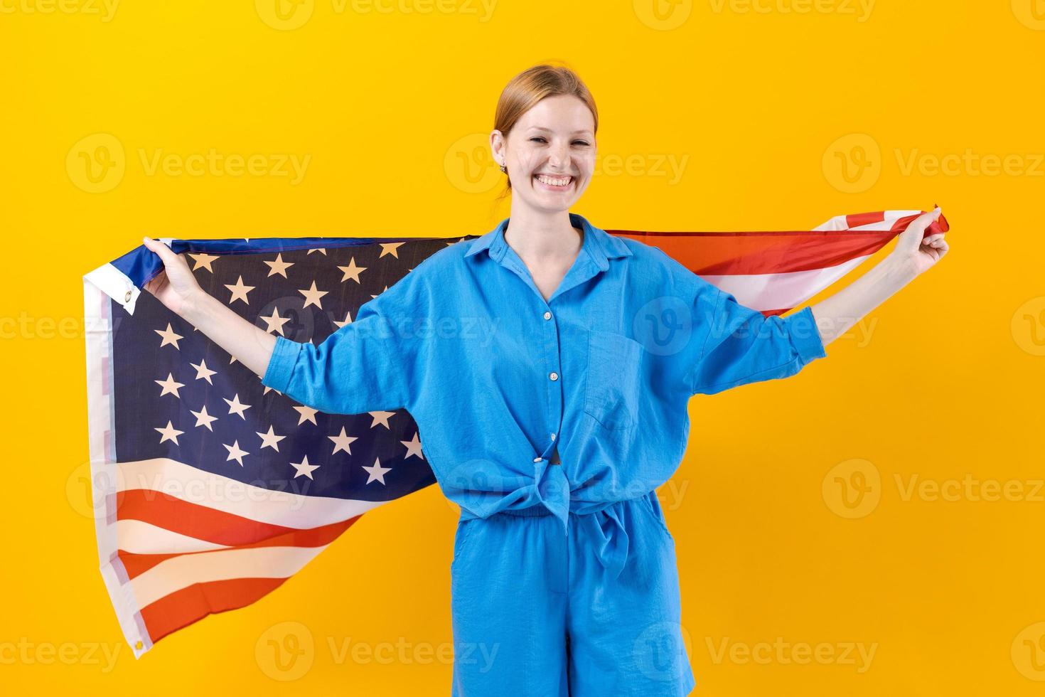 Caucasian girl. Happy young woman in blue clothes with USA flag isolated photo