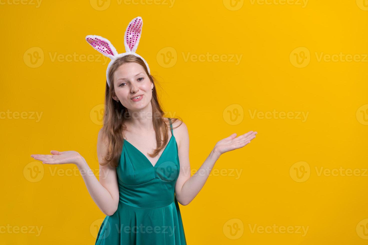 Cheerful young woman with fluffy pink bunny ears, disappointment aside photo