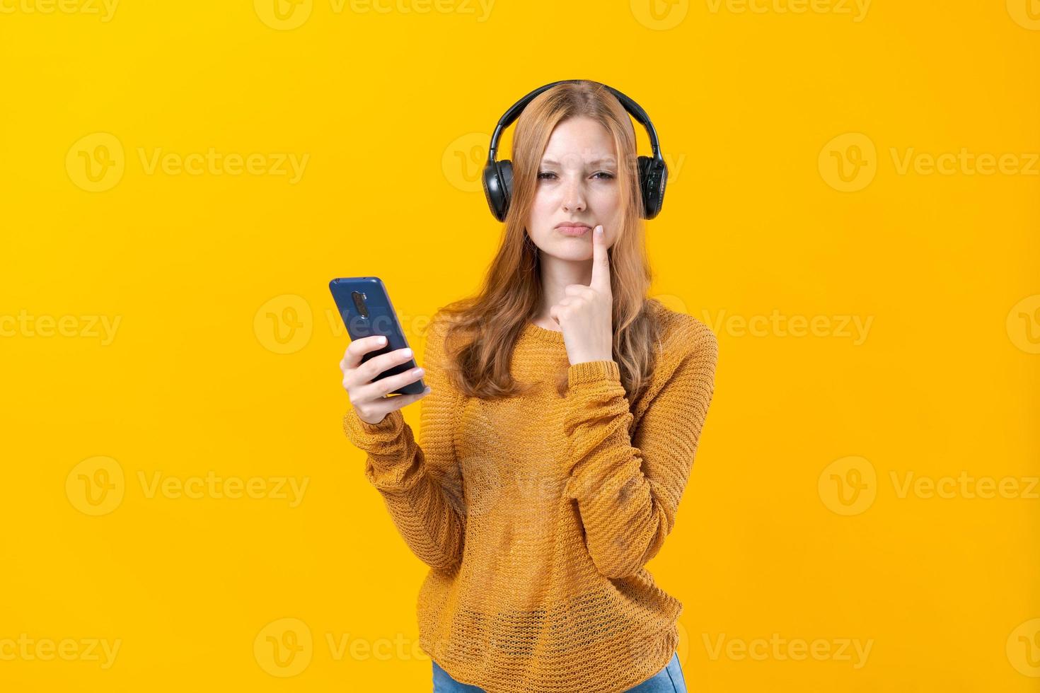 Image of emotional happy excited young woman listening to music with headphones photo