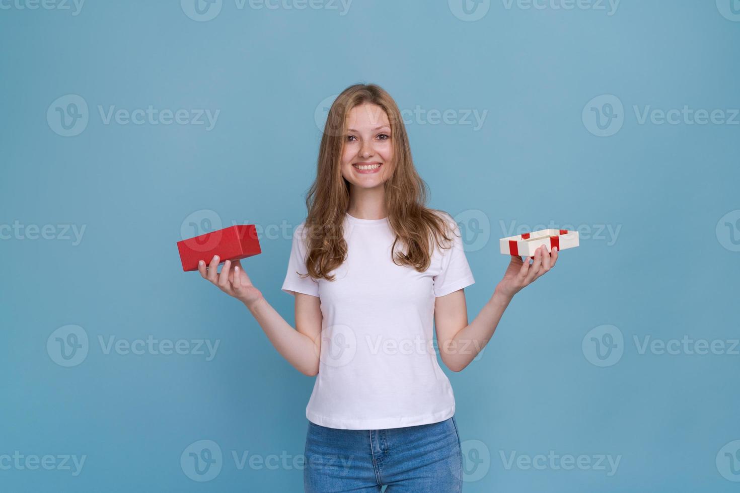 Excited young woman in white t-shirt isolated on blue background. photo