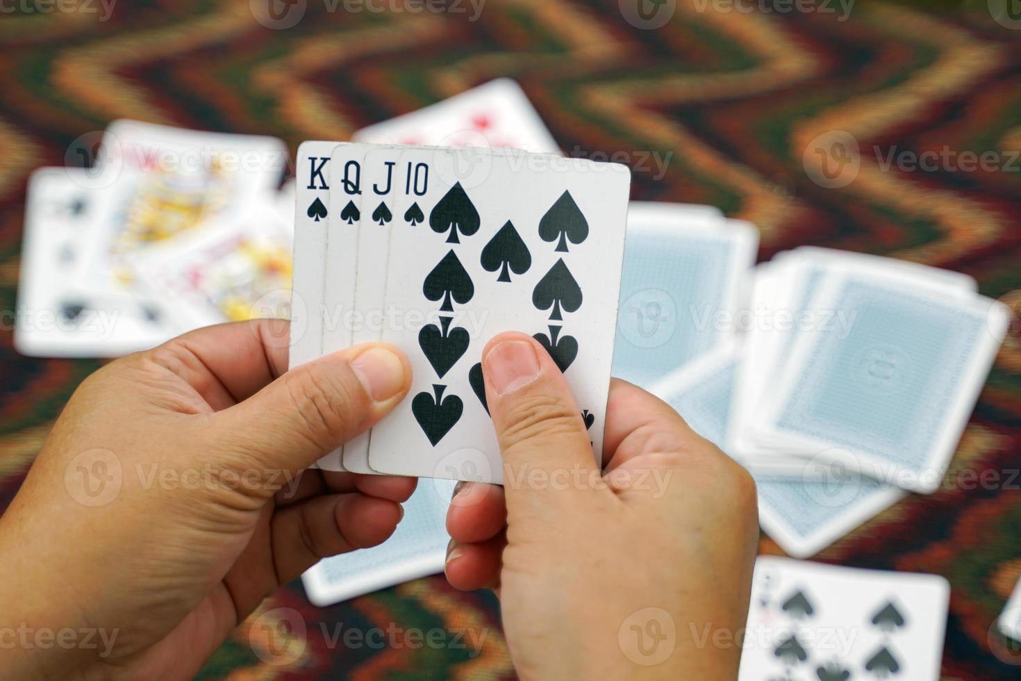 el primer plano de las cartas en la mano del jugador obtiene un rey, una reina, una jota y 10 picas, concepto de actividades de ocio familiar o camping. enfoque suave y selectivo. foto
