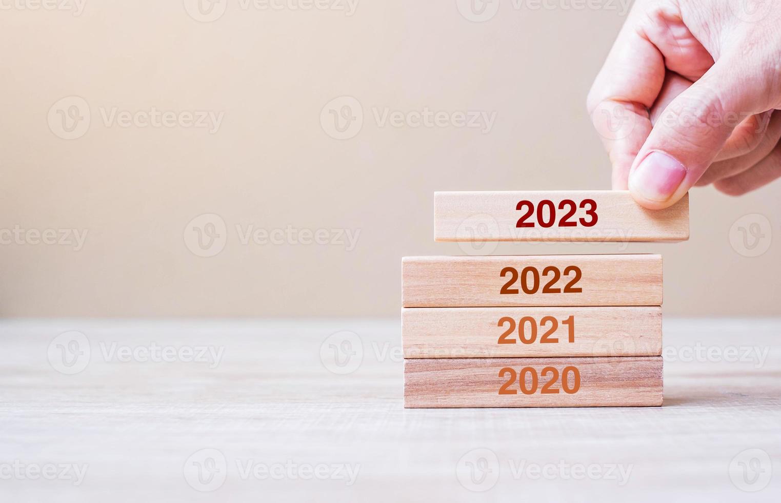 2023 bloque sobre 2022 y 2021 edificio de madera sobre fondo de mesa. planificación empresarial, gestión de riesgos, resolución, estrategia, solución, objetivo, nuevo año nuevo y felices conceptos de vacaciones foto