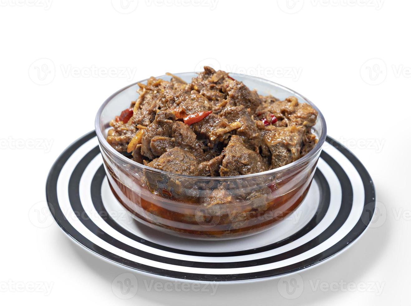 Traditional Beef Curry Served in trasparent bowl front view on ceramic plate photo