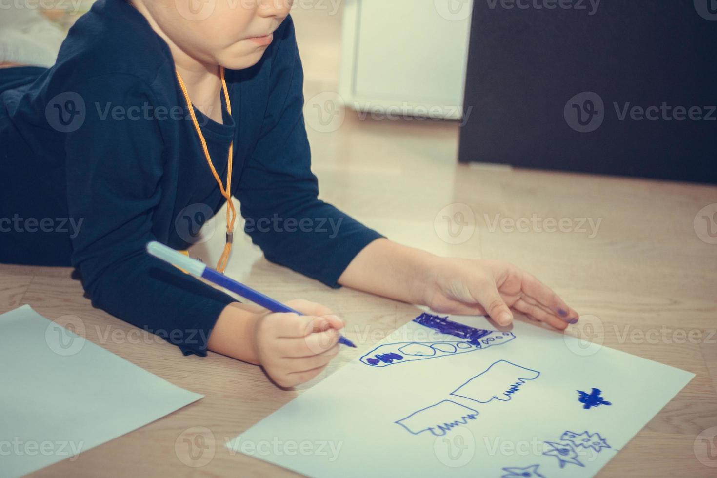 Unrecognizable kid coloring on the paper. photo