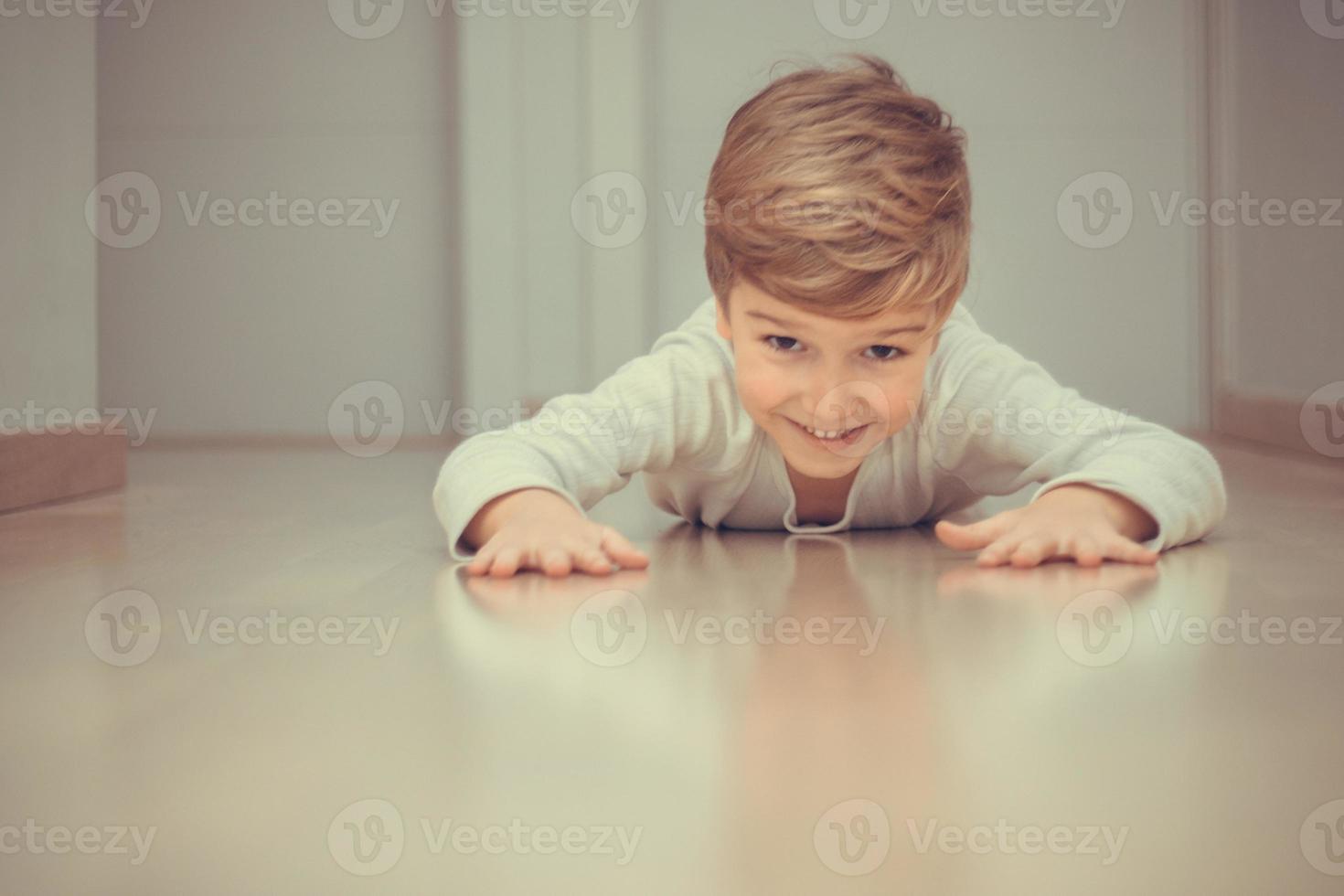 niño juguetón divirtiéndose en el suelo. foto