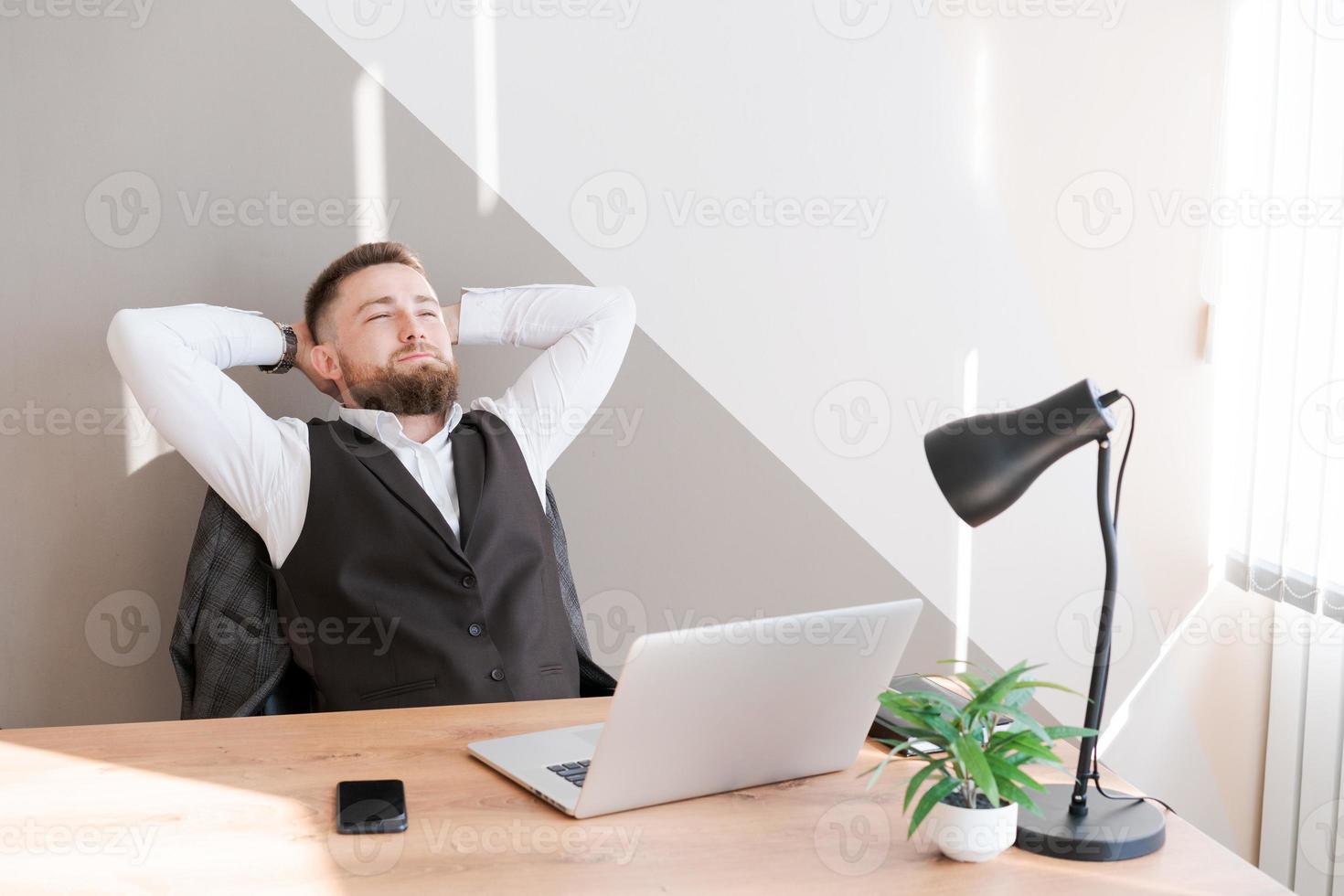 Handsome businessman is working with laptop in office, in business clothes photo