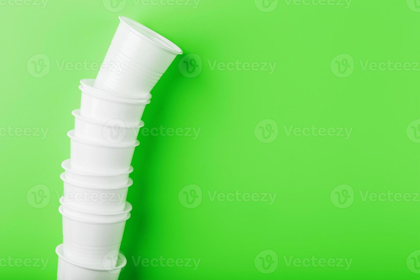 Disposable plastic tableware on a green background with free space. photo