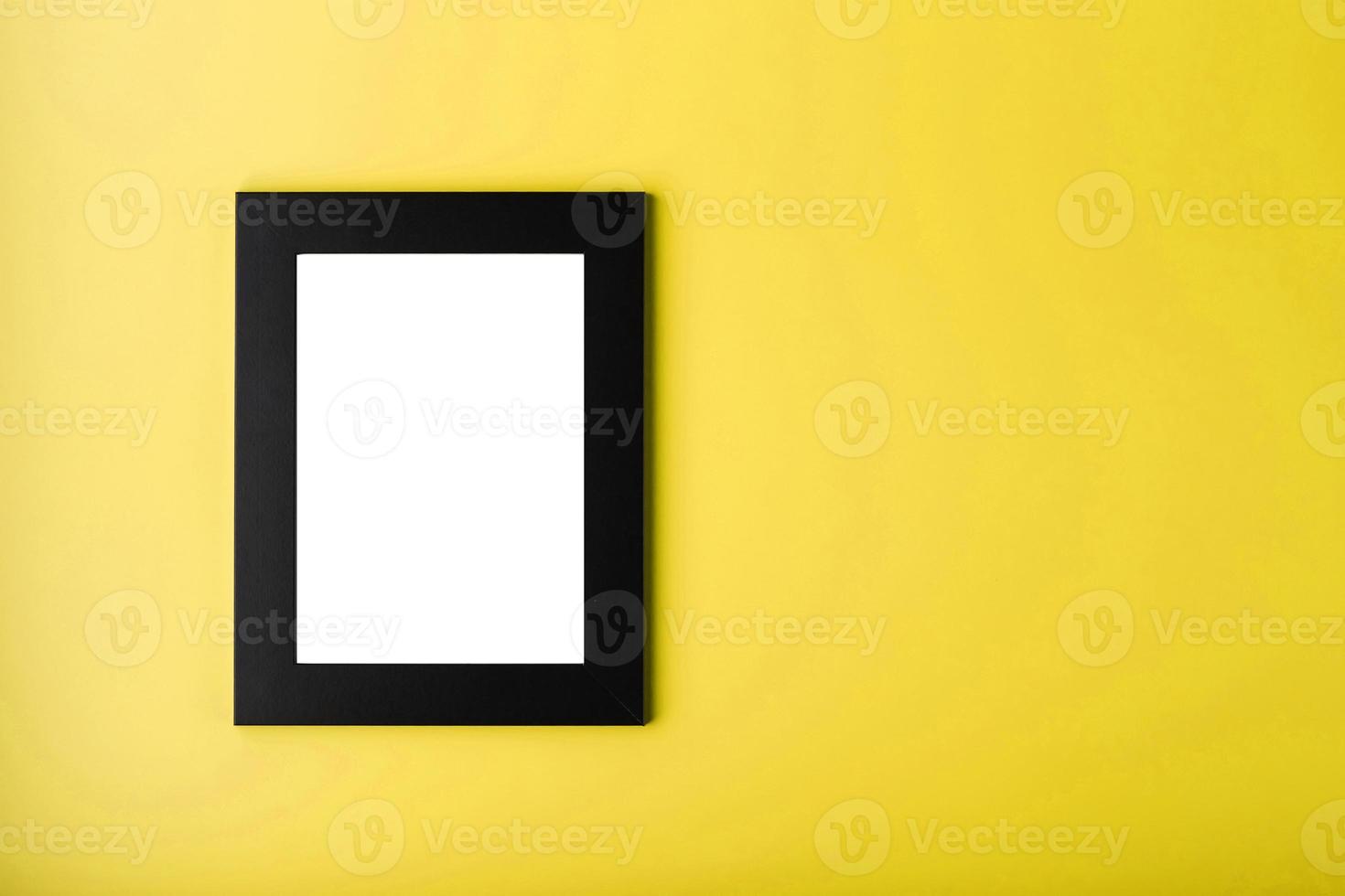 Black photo frame with free space on a yellow background.