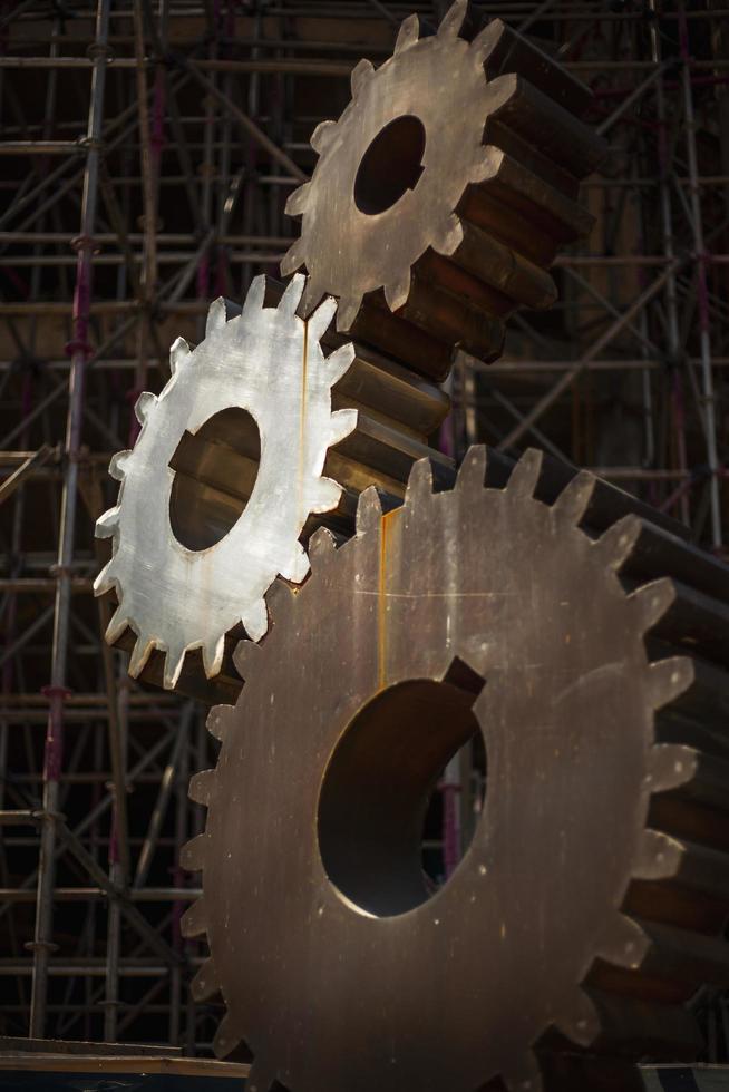 Close-up shot of steel gear teeth against construction site background. photo