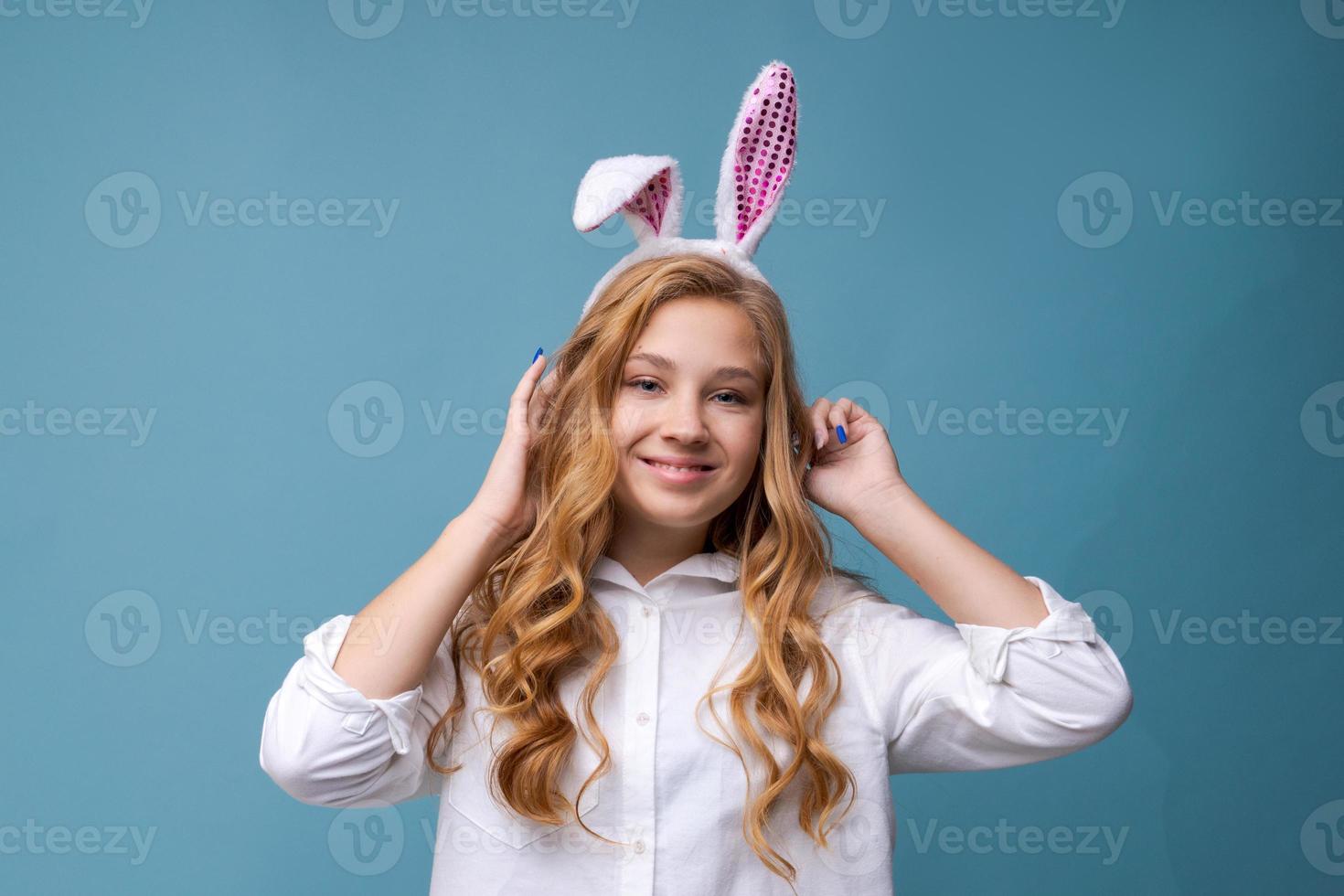 Young beautiful woman in cute easter bunny ears makes a normal gesture, plays photo