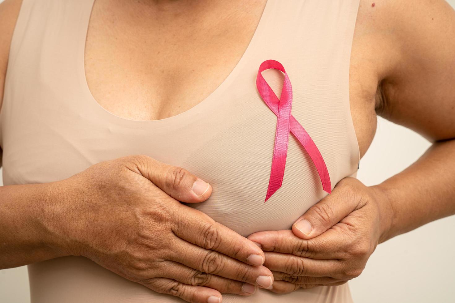 Breast cancer, pink ribbon at Asian senior lady for supporting awareness, symbol of World Breast Cancer Day. photo