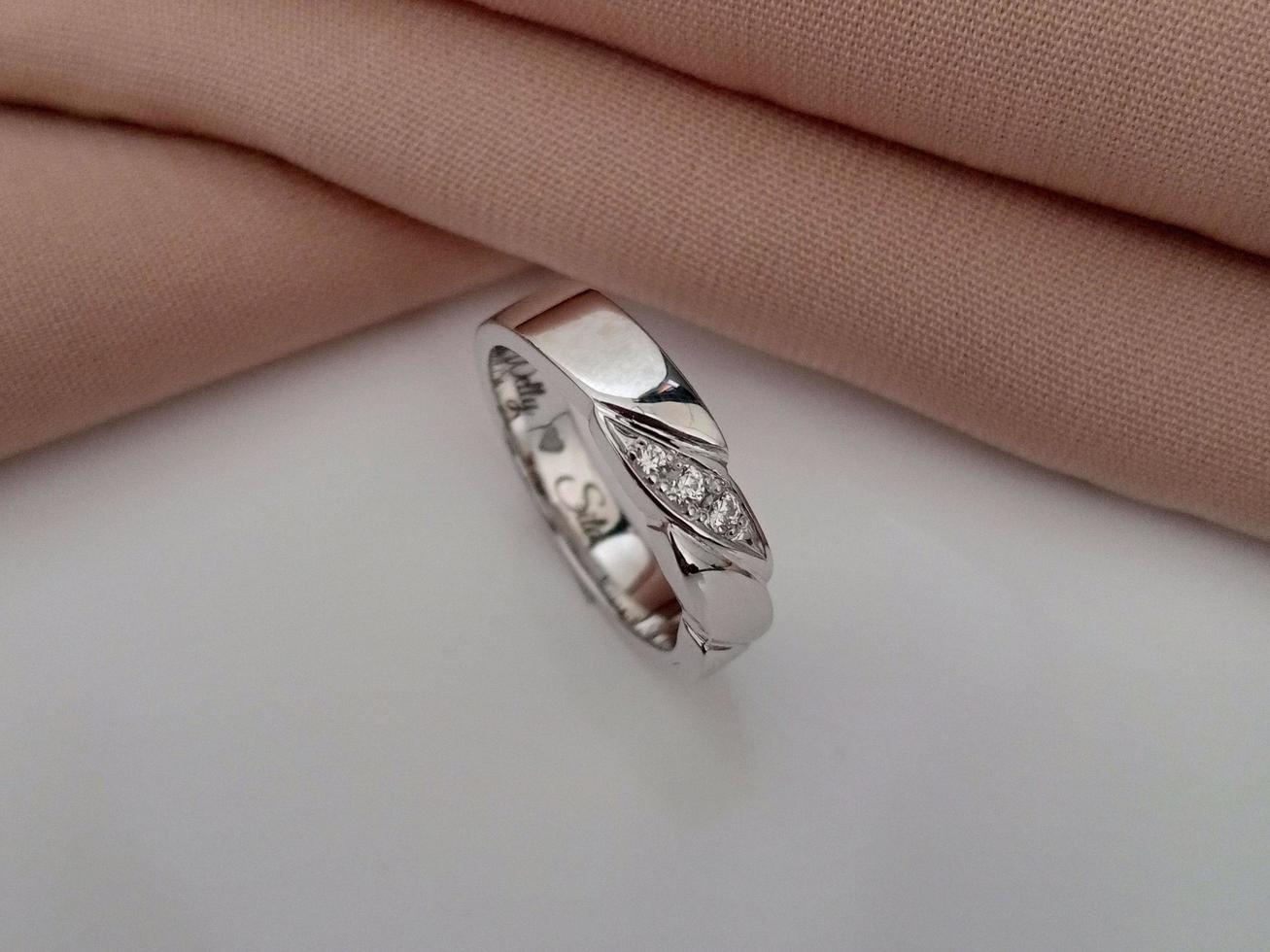 white gold wedding ring. Single ring with glossy and doff finishing with brown cloth background and white base photo